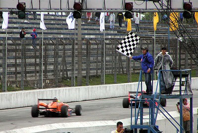 A chequered flag is waved to signal the end of a motor race