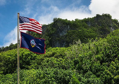The flag of Guam flying alongside the flag of the United States of America at the Guam National Wildlife Refuge unit at Ritidian Point