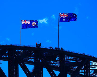 The flag of New South Wales (left) flying alongside the Australian national flag atop the Sydney Harbour Bridge in Sydney, New South Wales